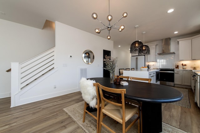 dining area featuring light wood-type flooring, visible vents, recessed lighting, an inviting chandelier, and baseboards