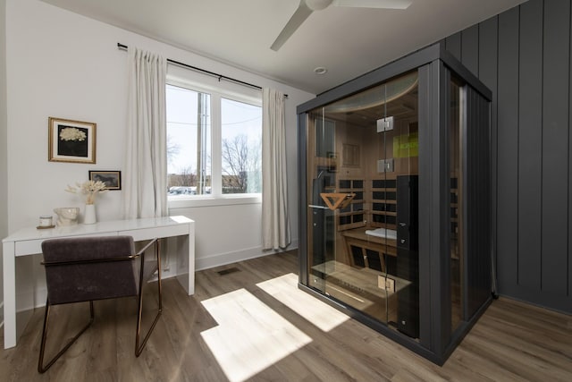 office with visible vents, a sauna, baseboards, wood finished floors, and a ceiling fan