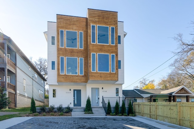 contemporary home with covered porch and fence