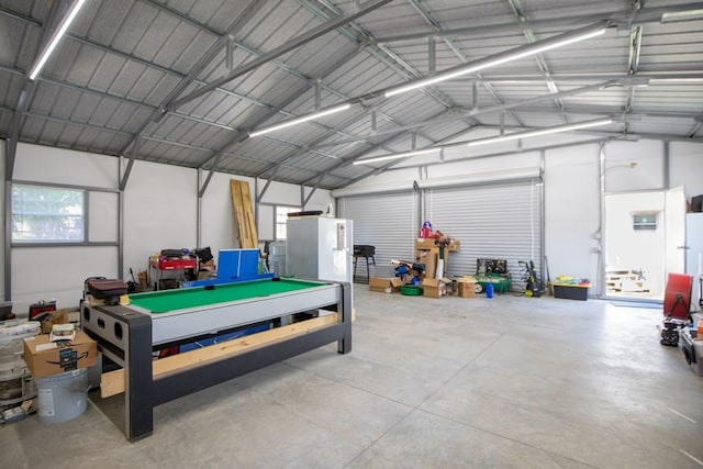 garage featuring metal wall and freestanding refrigerator