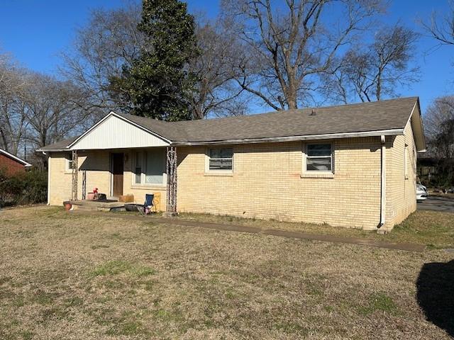 view of front of home with brick siding and a front lawn