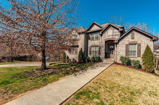 view of front of home with a front lawn and brick siding