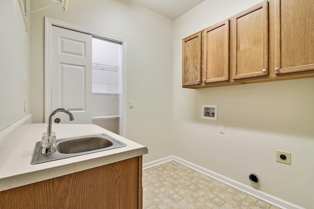 laundry room with light floors, baseboards, cabinet space, electric dryer hookup, and a sink