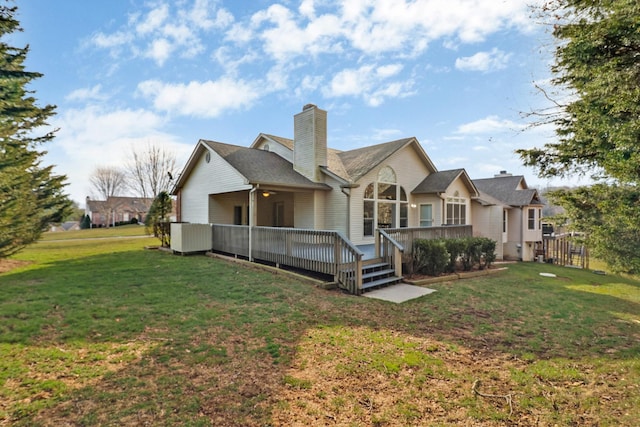 back of property with a yard, a wooden deck, and a chimney