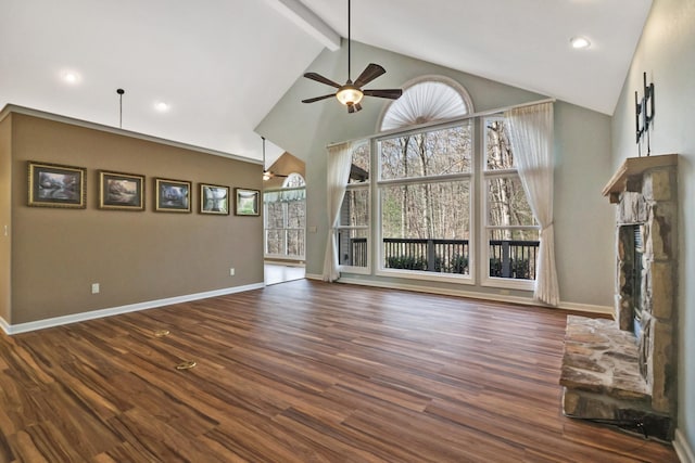 unfurnished living room featuring dark wood finished floors, plenty of natural light, baseboards, and beam ceiling