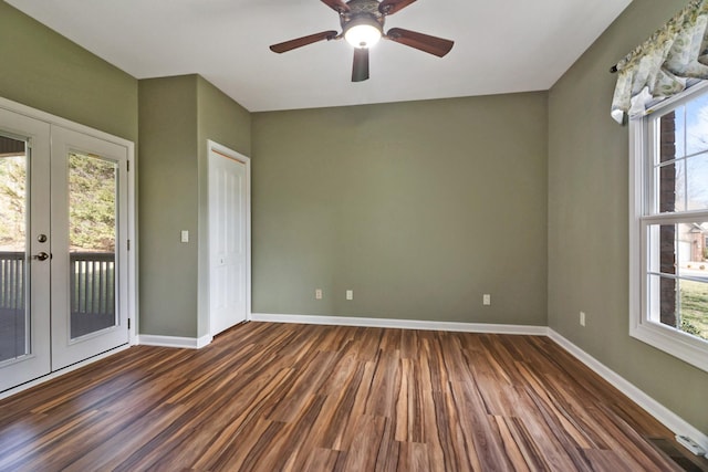 empty room with dark wood-type flooring, plenty of natural light, french doors, and baseboards