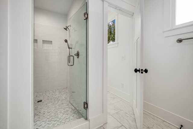 full bathroom with a shower stall, marble finish floor, and a wealth of natural light