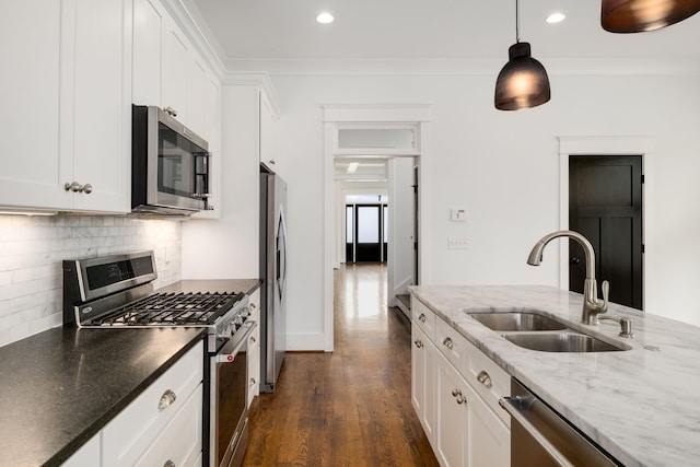 kitchen with a sink, crown molding, backsplash, and stainless steel appliances