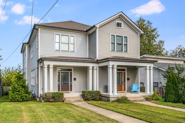 traditional-style home featuring a porch, a shingled roof, and a front lawn