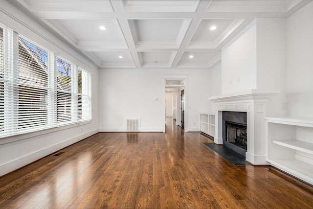 unfurnished living room with visible vents, baseboards, beamed ceiling, a fireplace with flush hearth, and wood finished floors