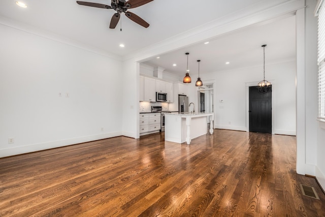 kitchen with visible vents, a breakfast bar, dark wood-style flooring, appliances with stainless steel finishes, and backsplash