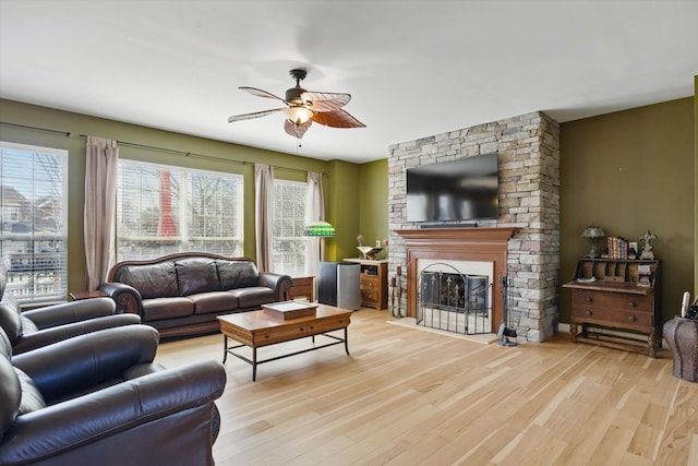 living room featuring a fireplace, light wood-style floors, and a wealth of natural light