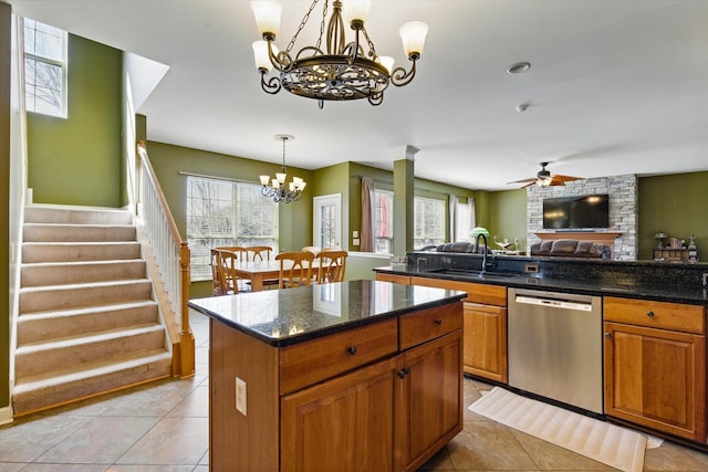 kitchen featuring plenty of natural light, a sink, stainless steel dishwasher, ceiling fan with notable chandelier, and open floor plan