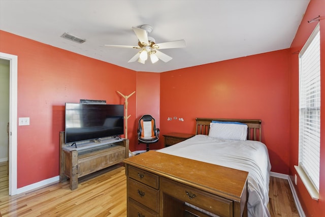 bedroom with visible vents, light wood-style flooring, baseboards, and ceiling fan