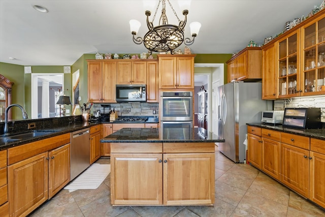 kitchen with a sink, a center island, backsplash, and stainless steel appliances