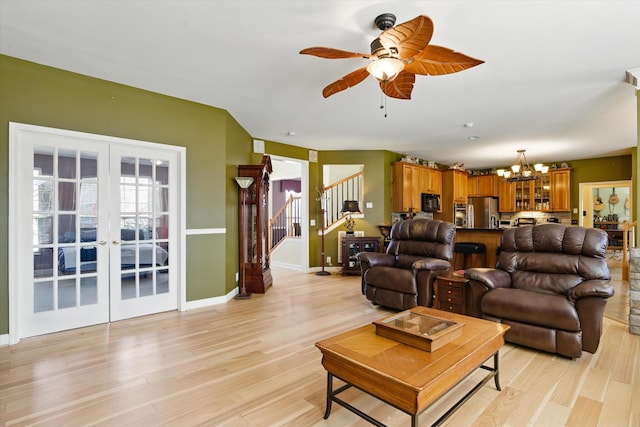 living area with light wood-style flooring, french doors, stairs, and baseboards