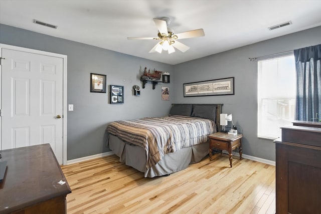 bedroom featuring visible vents, a ceiling fan, light wood-type flooring, and baseboards