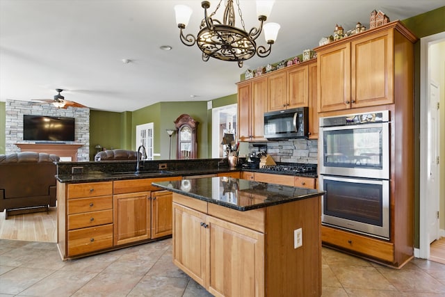 kitchen with a peninsula, a sink, open floor plan, double oven, and tasteful backsplash