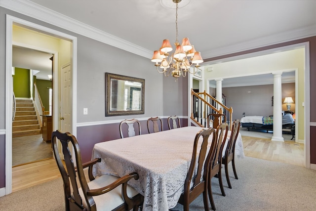 dining area featuring an inviting chandelier, ornamental molding, stairs, and ornate columns