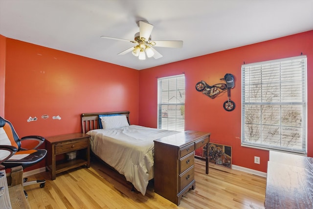 bedroom with light wood-style flooring, baseboards, and ceiling fan