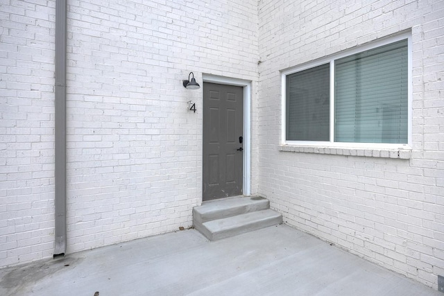 property entrance featuring brick siding