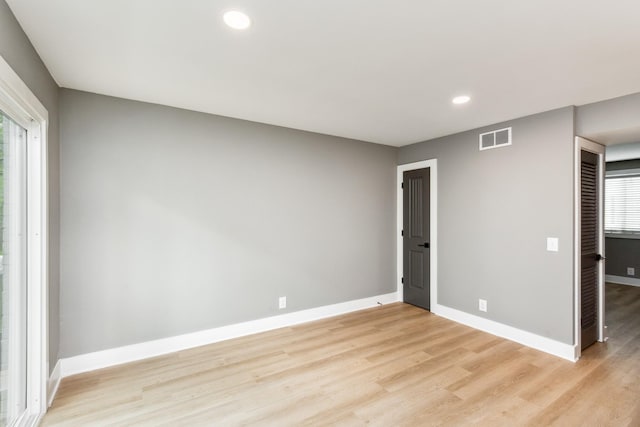 spare room with light wood finished floors, visible vents, recessed lighting, and baseboards