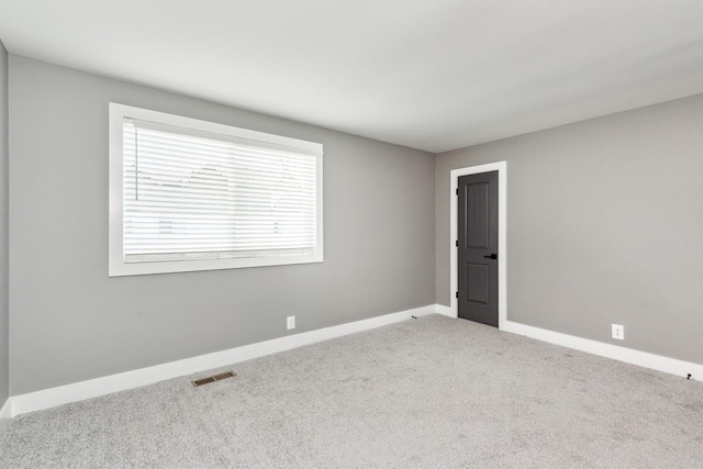 unfurnished room featuring visible vents, carpet flooring, and baseboards