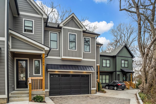 view of front facade with decorative driveway, a garage, board and batten siding, and roof with shingles