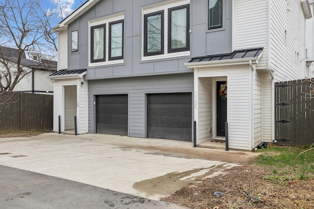 exterior space featuring driveway, a standing seam roof, fence, board and batten siding, and a garage