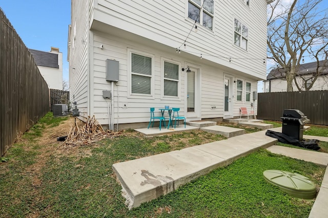 rear view of house with a patio area, cooling unit, and a fenced backyard