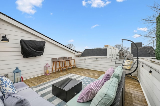 wooden terrace with an outdoor living space