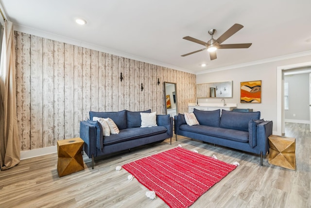 living area with baseboards, wood finished floors, and crown molding