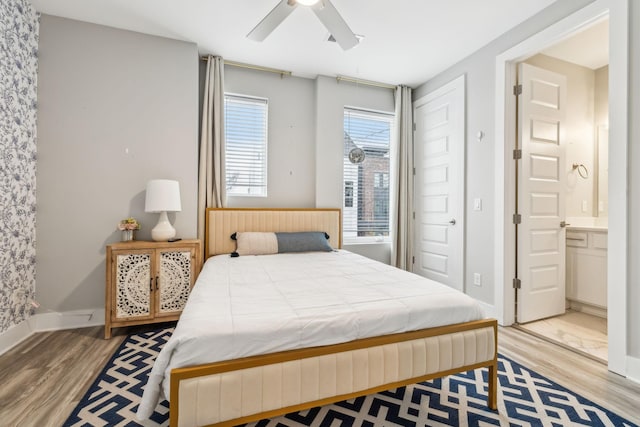 bedroom with light wood-style flooring, ensuite bathroom, baseboards, and ceiling fan