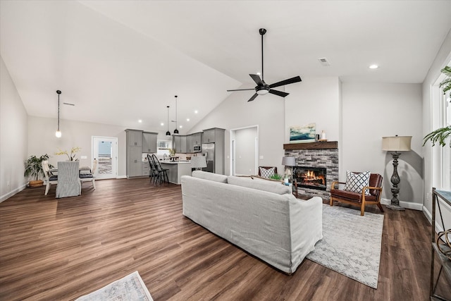 living room featuring visible vents, baseboards, dark wood-type flooring, and a fireplace