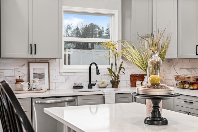 kitchen with dishwasher, light countertops, a sink, and gray cabinetry