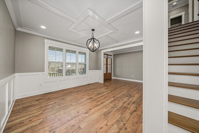 unfurnished room with a chandelier, a wainscoted wall, hardwood / wood-style floors, and ornamental molding