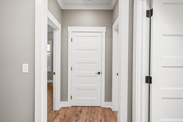 corridor with crown molding, baseboards, and wood finished floors