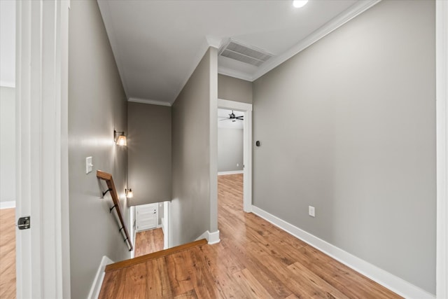 hall with baseboards, an upstairs landing, visible vents, and ornamental molding