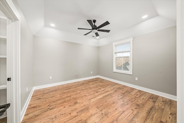 empty room featuring vaulted ceiling, a ceiling fan, baseboards, and wood-type flooring