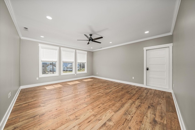 unfurnished room with visible vents, baseboards, hardwood / wood-style floors, and crown molding