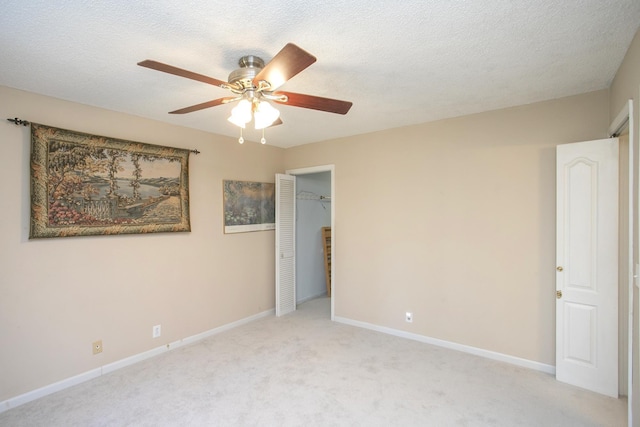 unfurnished bedroom with baseboards, light carpet, a textured ceiling, and a closet