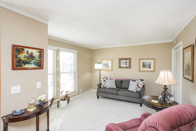 living area featuring carpet flooring, baseboards, and ornamental molding