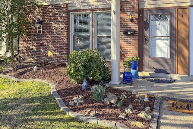 view of exterior entry featuring brick siding