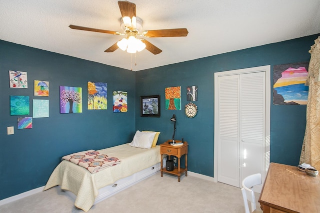 bedroom featuring a closet, carpet floors, baseboards, and a ceiling fan