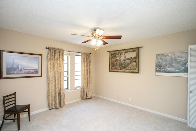 sitting room with baseboards, carpet floors, a textured ceiling, and ceiling fan