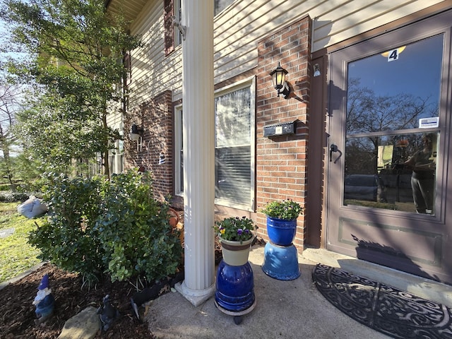 entrance to property featuring brick siding