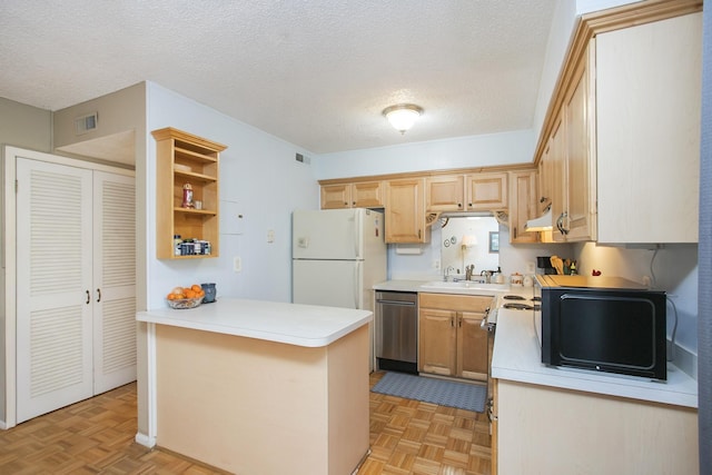 kitchen with visible vents, a peninsula, freestanding refrigerator, black microwave, and stainless steel dishwasher