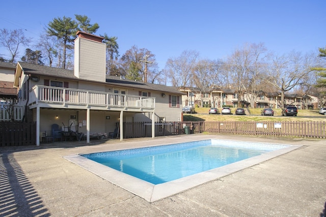 view of swimming pool with a residential view, a wooden deck, a fenced in pool, fence private yard, and a patio area