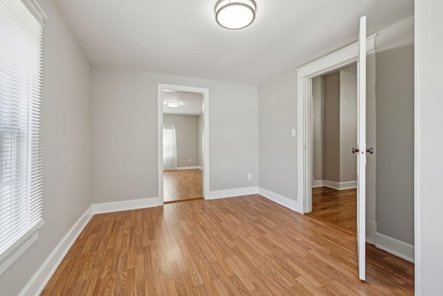 empty room featuring light wood-style flooring and baseboards