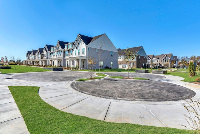 surrounding community featuring a yard, a residential view, and curved driveway